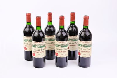 six bouteilles de vin rouge alignées sur une surface blanche