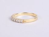 a yellow gold ring with five diamonds on the side