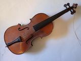 an old violin sitting on top of a white surface