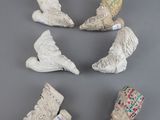 six figurines en céramique de formes et de tailles différentes posées sur une surface grise