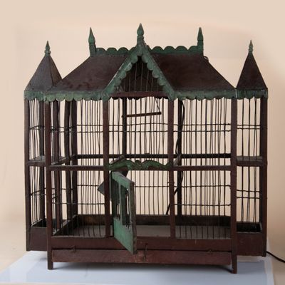 a small bird cage with a bird inside of it