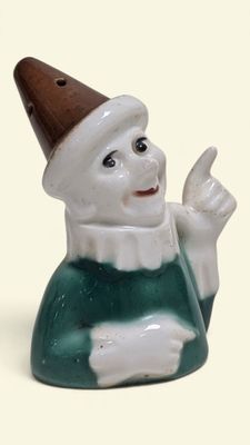 une figurine en céramique représentant un gnome coiffé d'un chapeau