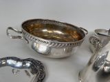 three silver dishes and a silver teapot on a table