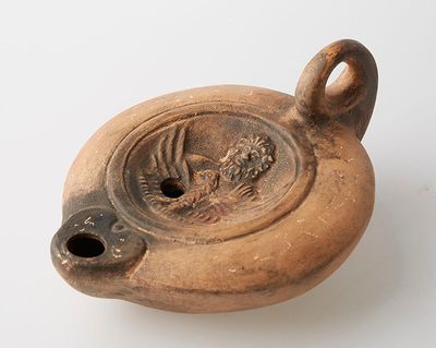 un vase marron orné d'un oiseau sur un fond blanc