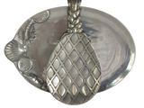 a silver plate with a pineapple on top of it