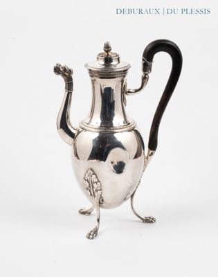 une théière en argent avec une anse noire, posée sur un socle