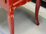 a small red table with a drawer on top of it