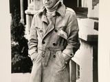 black and white photograph of a man in a trench coat and scarf
