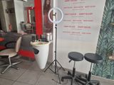 une photo d'un salon de coiffure avec un fauteuil et un miroir