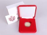une petite boîte rouge contenant une pièce d'or