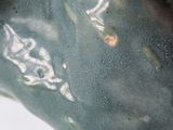 a close up of a green vase with a black base