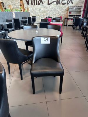 des tables et des chaises dans un restaurant, avec une enseigne accrochée au mur
