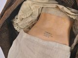 a doll in a bag with a book inside of it