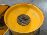 a yellow drum with a metal strainer in it