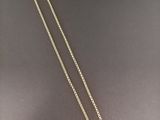 un collier en or orné d'un diamant blanc sur fond noir