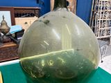 un grand vase vert posé sur un tapis vert