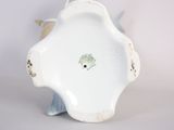 a small white vase with a flower decoration on it