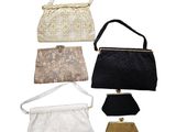 several different purses are lined up on a white surface