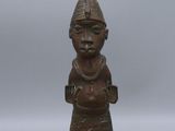 an old bronze figurine of a man with a hat on his head