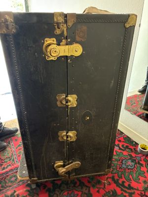 une valise noire posée sur un tapis rouge devant un miroir