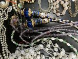 many different types of necklaces and bracelets on the table
