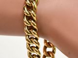 un bracelet à chaîne en or au poignet d'une femme