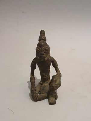 statue of a person kneeling on a white surface