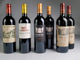 several bottles of wine are lined up on a white surface