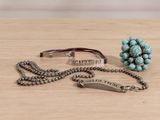 silver and turquoise beaded bracelet and ring on a wooden table