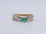 a close up of a ring with a green stone and diamonds