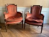 une paire de fauteuils en velours rouge dans un coin de la pièce