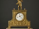 une image représentant une horloge dorée posée sur une table blanche