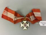 un ruban rayé orange et blanc orné d'une croix dorée