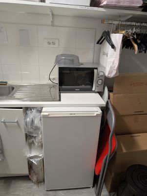a small kitchen with a refrigerator and a microwave in it
