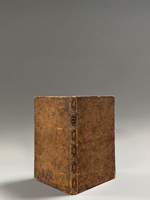 an old book sitting on top of a white surface