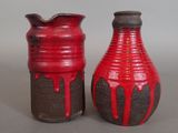two red vases sitting next to each other on a table