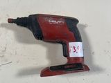une perceuse filaire rouge posée sur une surface blanche