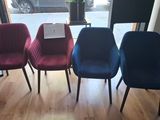 four chairs in a row in front of a window in a room