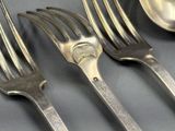 quatre fourchettes et une cuillère sur une table