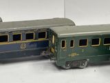 three toy trains sitting side by side on a white surface