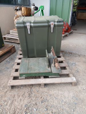 une grande caisse verte posée sur une palette dans une cour