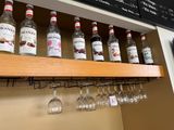 de nombreuses bouteilles et verres sur l'étagère au-dessus des verres à vin