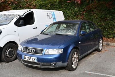 two cars parked in a parking lot next to each other