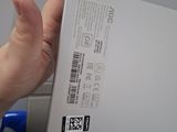 the back of a person holding a white laptop computer in their hand