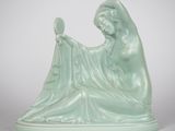 une statue représentant une femme tenant une balle dans la main