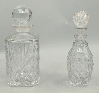 two clear glass bottles sitting next to each other on a white surface