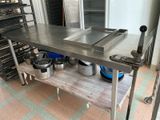 a large stainless steel table with pots and pans on it