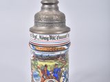 a beer stein with a statue on top of it