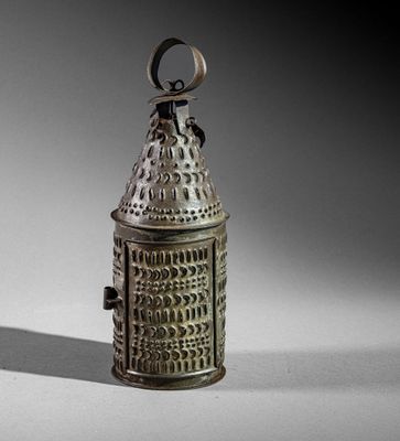 a small metal bell with a handle on a table