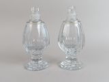 une paire de salières et poivrières en verre transparent posées sur une surface blanche